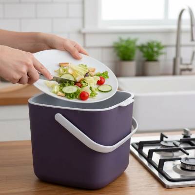Poubelle cuisine couleur violet reçoit les déchets de nourriture en vue du compostage