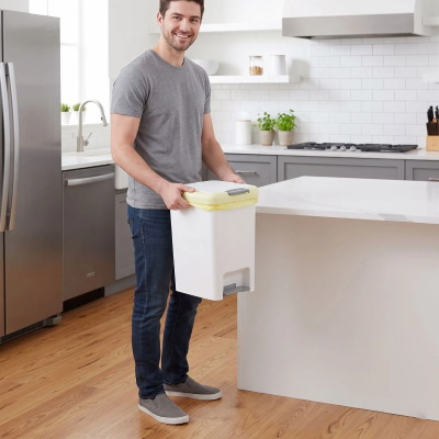 Poubelle de cuisine présentée par un homme dans sa cuisine